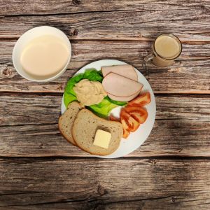 Zdjęcie przedstawia Dietę podstawową: Kawa zbożowa z mlekiem Zacierka na mleku Chleb mieszany pszenno-żytni Masło extra Pomidor Schab Kruchy z Liszek Sałata zielona Hummus